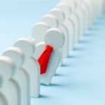 Staff recruitment. Headhunting. Many employees and the choice of a leader from the crowd. HR. A lot of white businessman and one in a red tie on a blue background