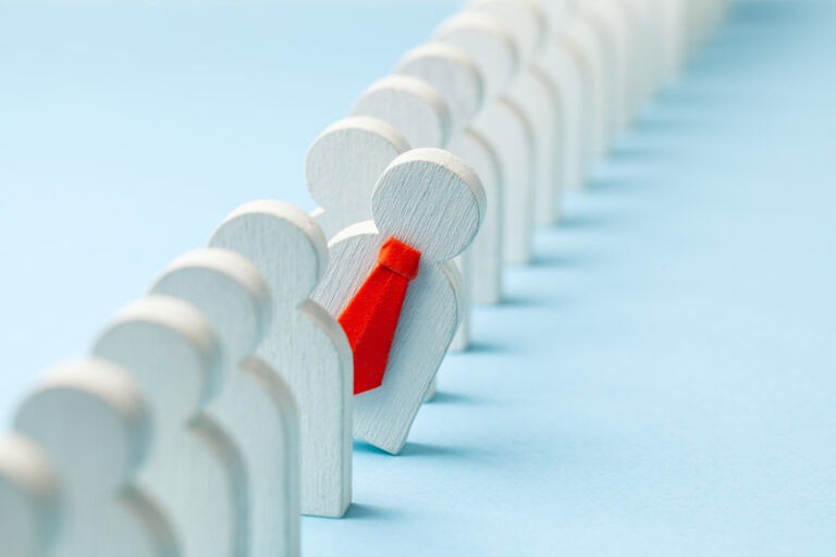 Staff recruitment. Headhunting. Many employees and the choice of a leader from the crowd. HR. A lot of white businessman and one in a red tie on a blue background