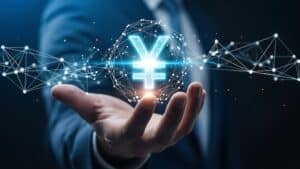 A person's hand holding a glowing yen symbol in a network, digital design