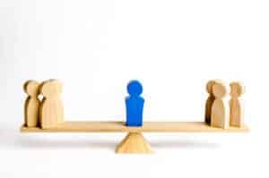 The leader stands on the scales between two groups of people. Resolving conflict situations. The union of two opposing groups of people. Conflict of interest. Leadership, choice side.